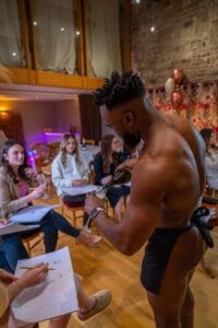 butler that's in the buff serving drinks | Life drawing class