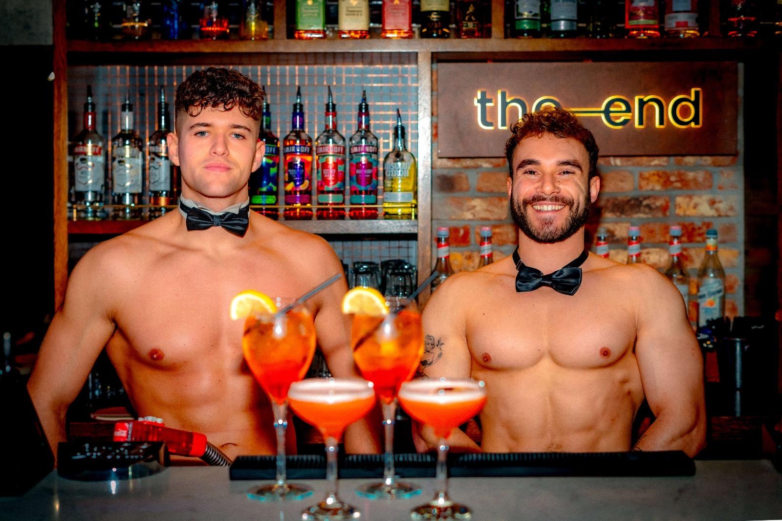 Buff butlers serving drinks behind the bar at The End, Leeds