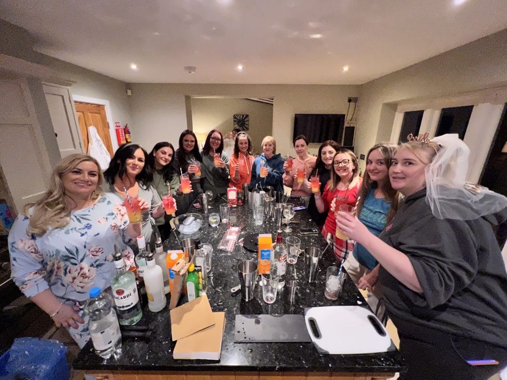 A hen party raising their cocktails at a Butler Direct cocktail masterclass