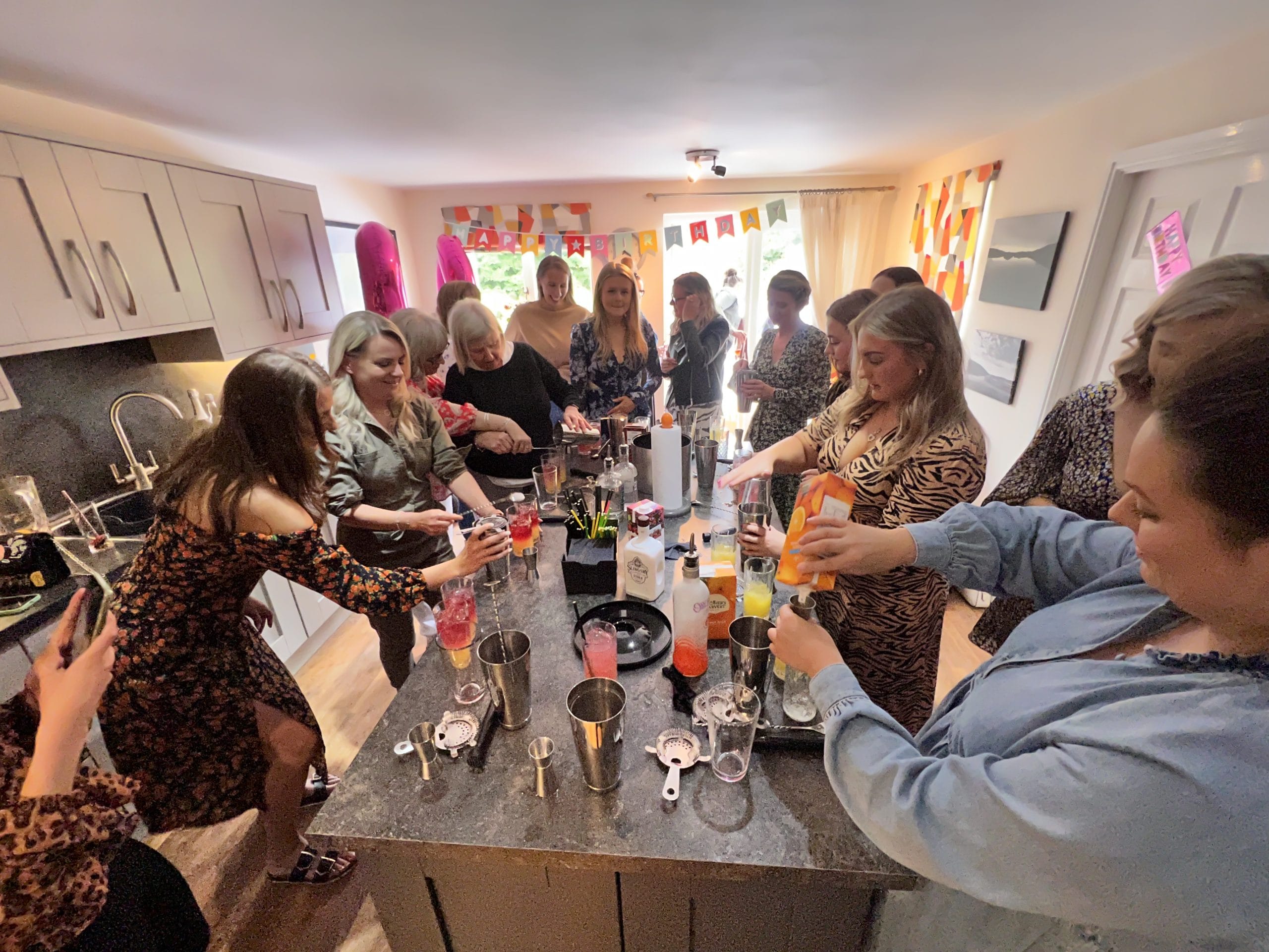 Guests making cocktails with a butler in the buff at a hen party