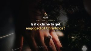 Engagement ring on a hand by a Christmas tree with fairy lights
